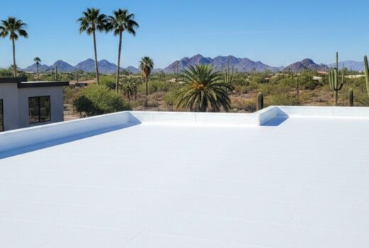 Professional installation of a seamless white spray foam roof on a Phoenix residential property under a clear blue sky.